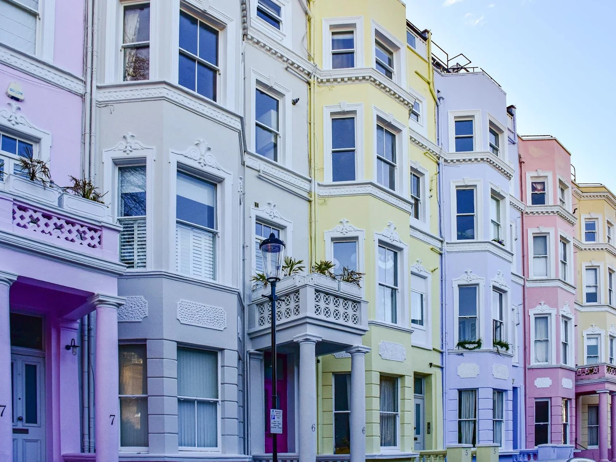 Row of tall pastel terraced houses with painted window frames in York