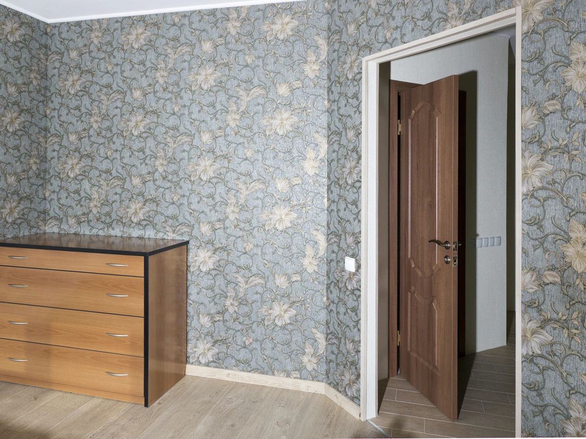 Blue floral wallpaper hung in a bedroom by York Painters, wallpaper installers in York