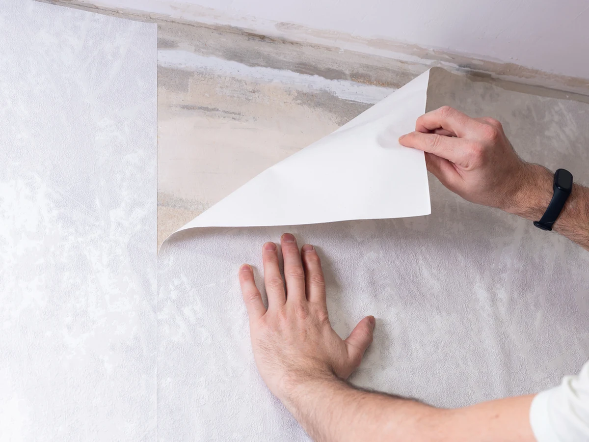 Hands applying wallpaper by York Painters, professional wallpaper installers